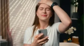 Ekspresi kebingungan seorang perempuan saat membaca pesan mencurigakan di ponsel yang diduga terkait penipuan digital.