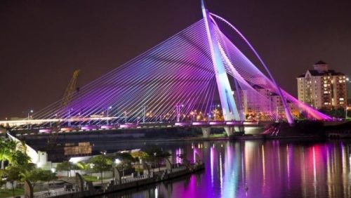 Jembatan Seri Wawasan tampak megah dengan cahaya LED warna-warni yang menerangi struktur kabel dan pylon saat malam hari di Putrajaya, Malaysia.