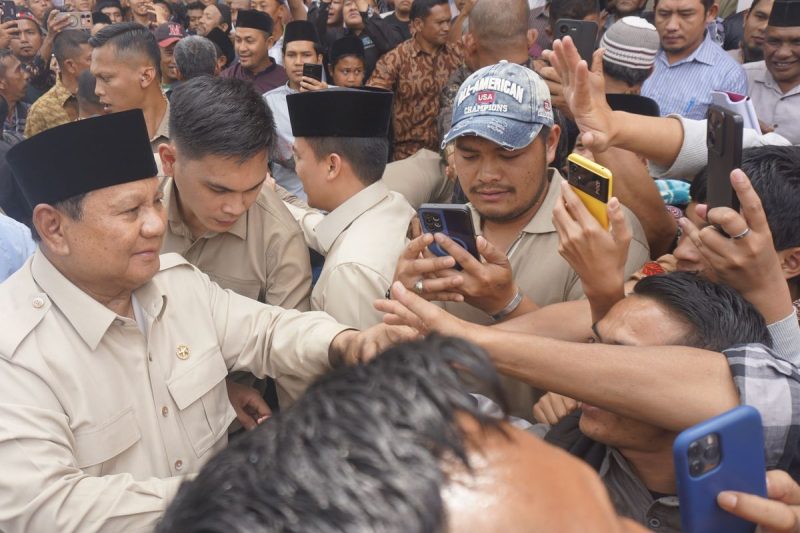 Presiden Prabowo Subianto menyalami warga saat mengunjungi Takengon, Aceh Tengah, Jumat (12/12/2025). Warga memadati lokasi dan banyak yang mengabadikan momen tersebut dengan ponsel.