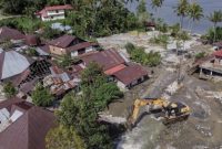 Alat berat membersihkan puing-puing rumah yang terdampak banjir dan longsor di Sumatera.