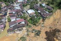 Permukiman warga tampak hancur akibat banjir bandang dan longsor, dengan sejumlah rumah roboh dan tanah tebing yang longsor hingga mendekati bangunan.