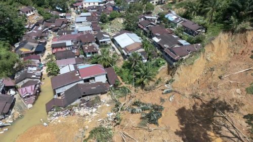 Permukiman warga tampak hancur akibat banjir bandang dan longsor, dengan sejumlah rumah roboh dan tanah tebing yang longsor hingga mendekati bangunan.