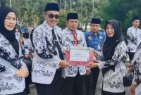 Wali Kota Sungai Penuh Alfin, SH menyerahkan penghargaan Juara 1 kepada Kepala TK Negeri Pembina, Eri Maria, S.Pd.
