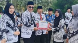 Wali Kota Sungai Penuh Alfin, SH menyerahkan penghargaan Juara 1 kepada Kepala TK Negeri Pembina, Eri Maria, S.Pd.