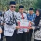 Wali Kota Sungai Penuh Alfin, SH menyerahkan penghargaan Juara 1 kepada Kepala TK Negeri Pembina, Eri Maria, S.Pd.