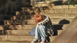 Ilustrasi remaja yang mengalami tekanan emosional akibat perundungan, baik di lingkungan nyata maupun digital.