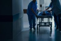 Petugas medis membawa pasien dengan dugaan stroke untuk penanganan darurat di rumah sakit.