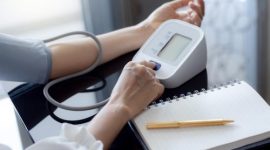 Seseorang mengukur tekanan darah dengan alat tensi digital sebagai bagian dari pemantauan kesehatan jantung.