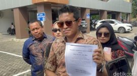 Kuasa hukum nenek Elina menunjukkan dokumen akta jual beli saat memberikan keterangan kepada wartawan di Polda Jawa Timur terkait dugaan pengusiran paksa dan sengketa rumah, Minggu (28/12/2025).