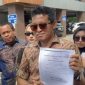 Kuasa hukum nenek Elina menunjukkan dokumen akta jual beli saat memberikan keterangan kepada wartawan di Polda Jawa Timur terkait dugaan pengusiran paksa dan sengketa rumah, Minggu (28/12/2025).