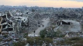 Warga berjalan di antara puing-puing bangunan yang hancur akibat serangan Israel di Jalur Gaza.