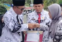 Kepala SD 004/XI Pelayang Raya, Lenza Hasmita, M.Pd, menerima penghargaan Juara 1 Sekolah Berprestasi dari Wali Kota Sungai Penuh, Alfin, SH, di halaman Kantor Walikota Sungai Penuh.