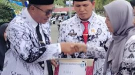 Kepala SD 004/XI Pelayang Raya, Lenza Hasmita, M.Pd, menerima penghargaan Juara 1 Sekolah Berprestasi dari Wali Kota Sungai Penuh, Alfin, SH, di halaman Kantor Walikota Sungai Penuh.