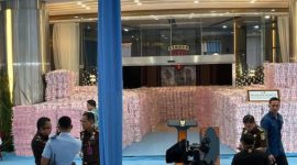 Petugas Kejaksaan Agung menata gunungan uang sitaan senilai Rp 6,6 triliun di lobi Gedung Jampidsus, Jakarta Selatan, Rabu (24/12/2025).