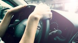 Pengemudi terlihat memegang stir mobil, menggambarkan sensasi perjalanan yang berbeda antara pergi dan pulang