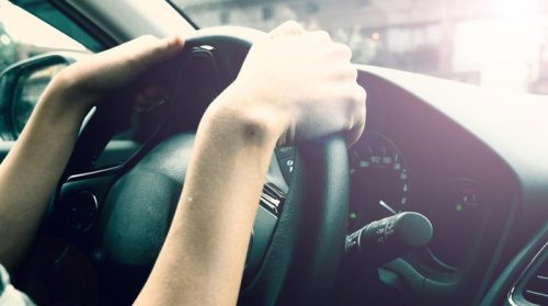 Pengemudi terlihat memegang stir mobil, menggambarkan sensasi perjalanan yang berbeda antara pergi dan pulang