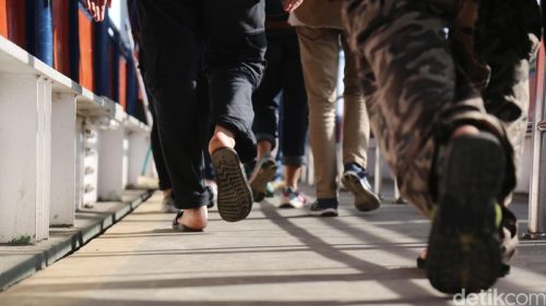 Ilustrasi sekelompok orang berjalan kaki bersama menyusuri gang-gang kota sebagai alternatif olahraga santai.