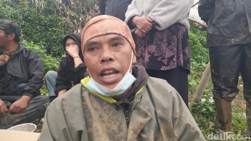 Asep Heri (45) beristirahat di tepi lokasi longsor Kampung Pasir Kuning, Bandung Barat, usai menggali lumpur untuk mencari putrinya yang hilang.