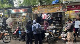 Seorang mekanik memperbaiki motor yang mogok setelah menerjang banjir di kawasan Jakarta Utara, Senin (12/1/2026).