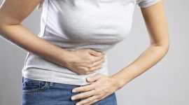 Ilustrasi seorang wanita memegang perut yang menggambarkan keluhan nyeri lambung dan gejala GERD.