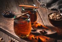 Segelas air rebusan kayu manis hangat yang dikenal memiliki berbagai manfaat kesehatan alami.