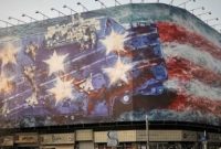 Mural di Alun-alun Enghelab, Teheran, menampilkan pesawat rusak di dek kapal induk sebagai peringatan Iran kepada Amerika Serikat.