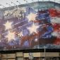 Mural di Alun-alun Enghelab, Teheran, menampilkan pesawat rusak di dek kapal induk sebagai peringatan Iran kepada Amerika Serikat.