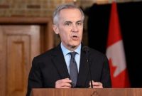 Perdana Menteri Kanada, Mark Carney, menyampaikan pernyataan resmi di hadapan media dengan bendera Kanada di belakangnya.