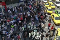 Mahasiswa menggelar aksi protes anti-pemerintah di Universitas Teknologi Sharif, Teheran, sambil membawa bendera nasional Iran.