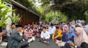 Warga duduk bersila menggelar tahlilan di depan rumah Presiden Jokowi di Solo
