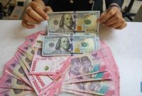  Petugas memperlihatkan pecahan dolar AS dan rupiah di gerai penukaran uang PT Ayu Masagung, Jakarta.(CNBC Indonesia/Faisal Rahman)