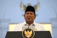 Presiden Prabowo Subianto memberikan sambutan resmi di Istana Kepresidenan dengan latar lambang negara Garuda Pancasila.