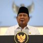 Presiden Prabowo Subianto memberikan sambutan resmi di Istana Kepresidenan dengan latar lambang negara Garuda Pancasila.