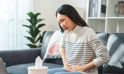 Ilustrasi pria memegang perut akibat rasa begah setelah menyantap hidangan berbuka puasa.