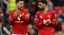 Diogo Dalot dan Bruno Fernandes menyapa suporter usai laga Manchester United vs Aston Villa di Old Trafford, 15 Maret 2026. (AFP/Oli Scarff)