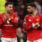 Diogo Dalot dan Bruno Fernandes menyapa suporter usai laga Manchester United vs Aston Villa di Old Trafford, 15 Maret 2026. (AFP/Oli Scarff)
