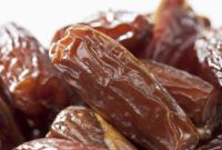 Tampilan kurma Tunisia jenis deglet nour yang memiliki warna cokelat keemasan, permukaan halus, dan daging buah semi-transparan.
