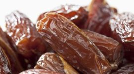 Tampilan kurma Tunisia jenis deglet nour yang memiliki warna cokelat keemasan, permukaan halus, dan daging buah semi-transparan.