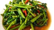 Tumis kangkung belacan pedas gurih dengan aroma terasi khas Malaysia, disajikan di piring putih