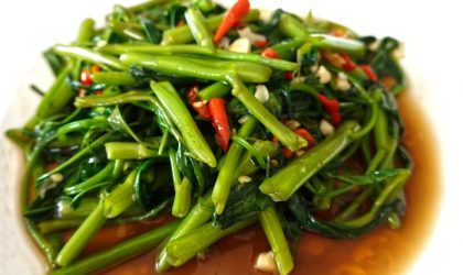 Tumis kangkung belacan pedas gurih dengan aroma terasi khas Malaysia, disajikan di piring putih