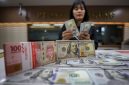 Karyawan menunjukan mata uang dolar AS dan rupiah di salah satu tempat penukaran uang di Jakarta