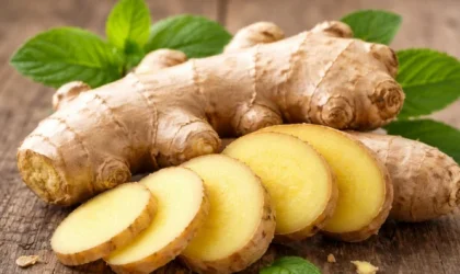 Jahe segar utuh dan jahe yang sudah diiris di atas permukaan kayu