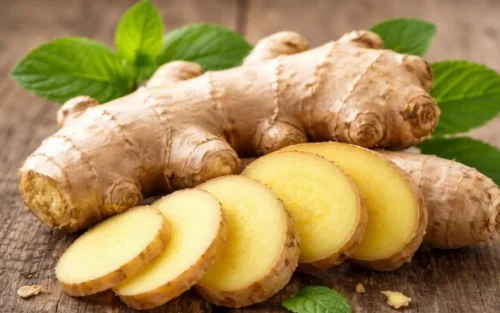 Jahe segar yang ditampilkan dalam bentuk utuh dan irisan tipis untuk menunjukkan tekstur dan warna alaminya.