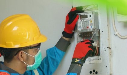 Ilustrasi petugas PLN memeriksa meteran listrik di rumah pelanggan