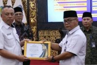 Kepala Dinas PPPAPPKB Kota Sungai Penuh menerima penghargaan dari BKKBN dalam ajang Genting Collaboration Summit 2025 di Jambi.