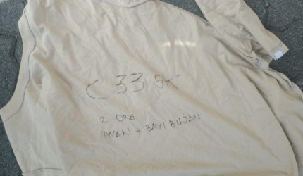 Baju bertuliskan kode darurat yang dilempar penghuni Apartemen Mediterania Jakarta Barat saat kebakaran untuk meminta bantuan evakuasi Damkar.