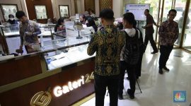 Sejumlah pengunjung melakukan transaksi pembelian emas batangan di Galeri 24