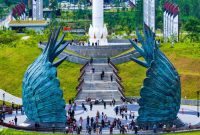 Masyarakat mengunjungi kawasan Plaza Seremoni di Kawasan Inti Pusat Pemerintahan (KIPP) Nusantara dengan latar patung sayap Garuda.