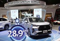 Pengunjung melihat Toyota Veloz Hybrid di showroom sambil memperhatikan informasi harga dan estimasi pajak tahunan kendaraan hybrid tersebut.