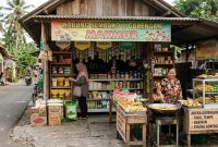 Seorang pedagang melayani pembeli di warung sembako sekaligus menjual gorengan di teras rumah